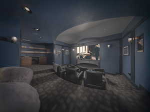 Carpeted home theater room featuring a dry bar, baseboards, and a textured ceiling