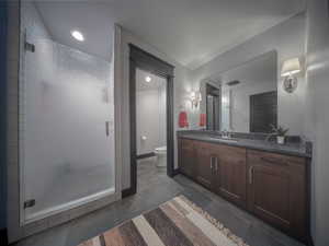 Full bath with visible vents, toilet, a stall shower, vanity, and baseboards