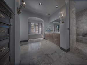 Primary Bathroom with a freestanding tub, recessed lighting, vanity, baseboards, and marble finish floor