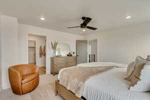 Bedroom featuring a spacious closet, baseboards, light carpet, and recessed lighting