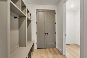 Mudroom with light wood finished floors and baseboards