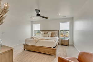 Bedroom with ceiling fan, light carpet, visible vents, and baseboards