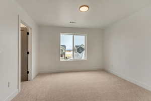 Unfurnished room with light carpet, visible vents, and baseboards
