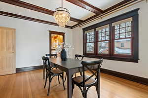 Wood box beam ceilings, glass chandelier, and top down bottom up shades