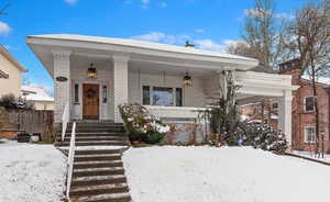 View of front of house featuring covered porch with glass lanterns, Sunday Porch Swing, and Porte Cochere