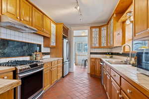 Kitchen with tile flooring, leaded glass cabinets, and stainless steel appliances