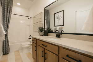 Full bathroom with recessed lighting, vanity, toilet, and shower / bath combo with shower curtain