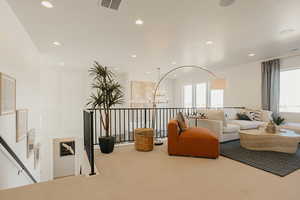 Living room featuring recessed lighting, visible vents, a notable chandelier, and carpet flooring