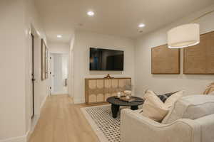 Living room featuring baseboards, wood finished floors, and recessed lighting