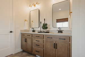 Full bathroom with double vanity, baseboards, a sink, and tile patterned floors