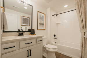 Bathroom featuring visible vents, toilet, tile patterned flooring, shower / bath combination with curtain, and vanity