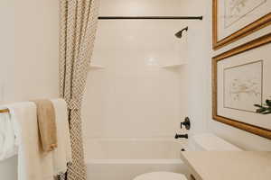 Full bath featuring toilet, shower / bathtub combination with curtain, and vanity