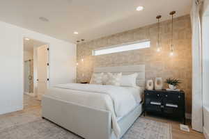 Bedroom featuring baseboards, light wood-type flooring, tile walls, and recessed lighting