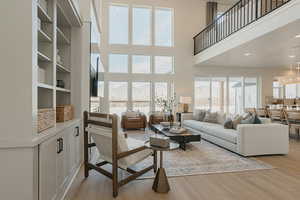 Living area with a towering ceiling, a mountain view, and light wood-style floors