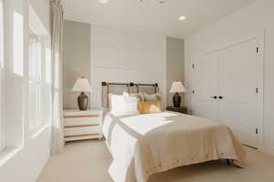 Bedroom with a closet, recessed lighting, and light colored carpet