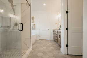 Full bathroom with a soaking tub, recessed lighting, an enclosed shower, and vanity