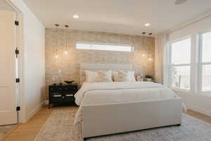 Bedroom featuring recessed lighting, baseboards, tile walls, and light wood finished floors