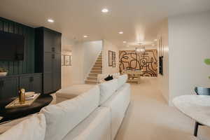 Living room with light carpet, stairway, baseboards, and recessed lighting