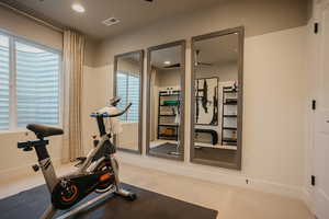 Workout area featuring light carpet, visible vents, and baseboards