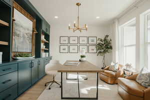 Office area with light wood-style floors, recessed lighting, and an inviting chandelier