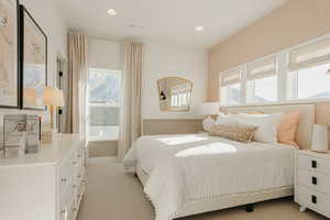 Bedroom with wallpapered walls, baseboards, visible vents, light colored carpet, and recessed lighting