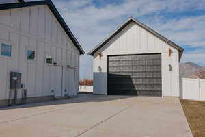 Detached garage featuring fence and a mountain view