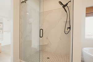 Bathroom with plenty of natural light and a marble finish shower