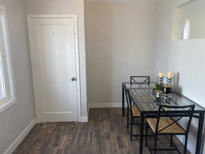 Dining space with baseboards and dark wood-type flooring