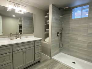 Full bath with a walk in shower, wood finished floors, and vanity