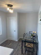 Office featuring baseboards, dark wood-style flooring, and a notable chandelier