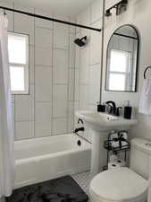 Full bathroom with shower / bath combo with shower curtain, toilet, and tile patterned floors