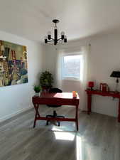 Office featuring a notable chandelier, baseboards, and wood finished floors