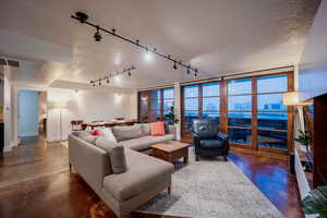 Living room with a view of city, visible vents, concrete flooring, and a textured ceiling