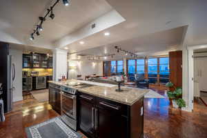 Kitchen featuring a center island, appliances with stainless steel finishes, open floor plan, a textured ceiling, and beverage cooler