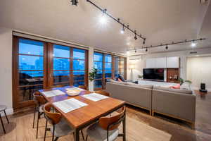 Dining area featuring a textured ceiling, concrete flooring, visible vents, a wall mounted AC, and a view of city