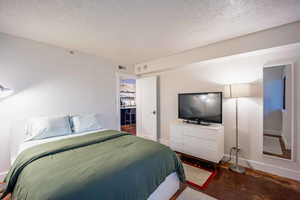 Bedroom featuring visible vents, concrete floors, a textured ceiling, and baseboards