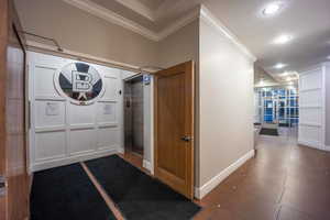 Foyer featuring recessed lighting, crown molding, dark tile patterned floors, baseboards, and elevator