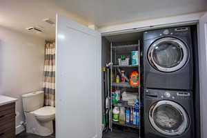 Laundry room with stacked washer and dryer and laundry area