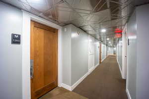 Hallway featuring carpet and baseboards