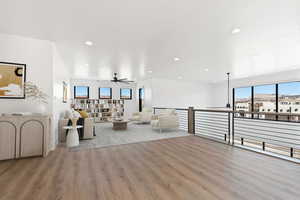 Unfurnished living room with ceiling fan, wood finished floors, and recessed lighting