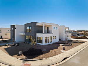 View of front of property featuring a balcony and stucco siding