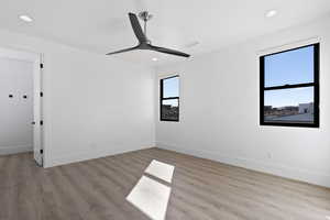 Unfurnished room featuring light wood finished floors, ceiling fan, and baseboards