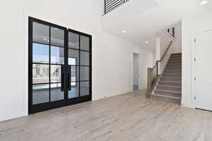 Interior space with light wood-style flooring, stairway, baseboards, and recessed lighting