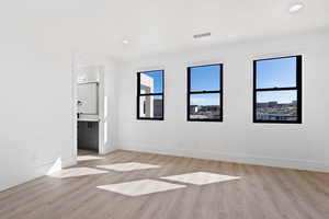 Unfurnished bedroom featuring light wood-type flooring, visible vents, and baseboards