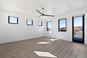 Spare room with light wood-type flooring, a healthy amount of sunlight, baseboards, and recessed lighting