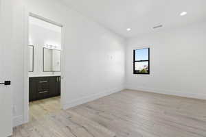 Unfurnished bedroom with light wood finished floors, baseboards, visible vents, and recessed lighting