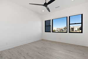 Empty room featuring light wood-style flooring, plenty of natural light, visible vents, and baseboards