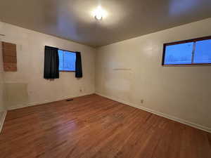 Unfurnished room with visible vents, baseboards, and wood finished floors