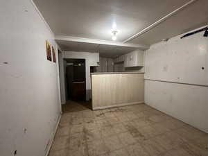 Kitchen featuring light floors and white cabinetry