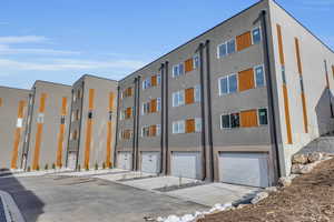 View of building exterior featuring driveway and an attached garage